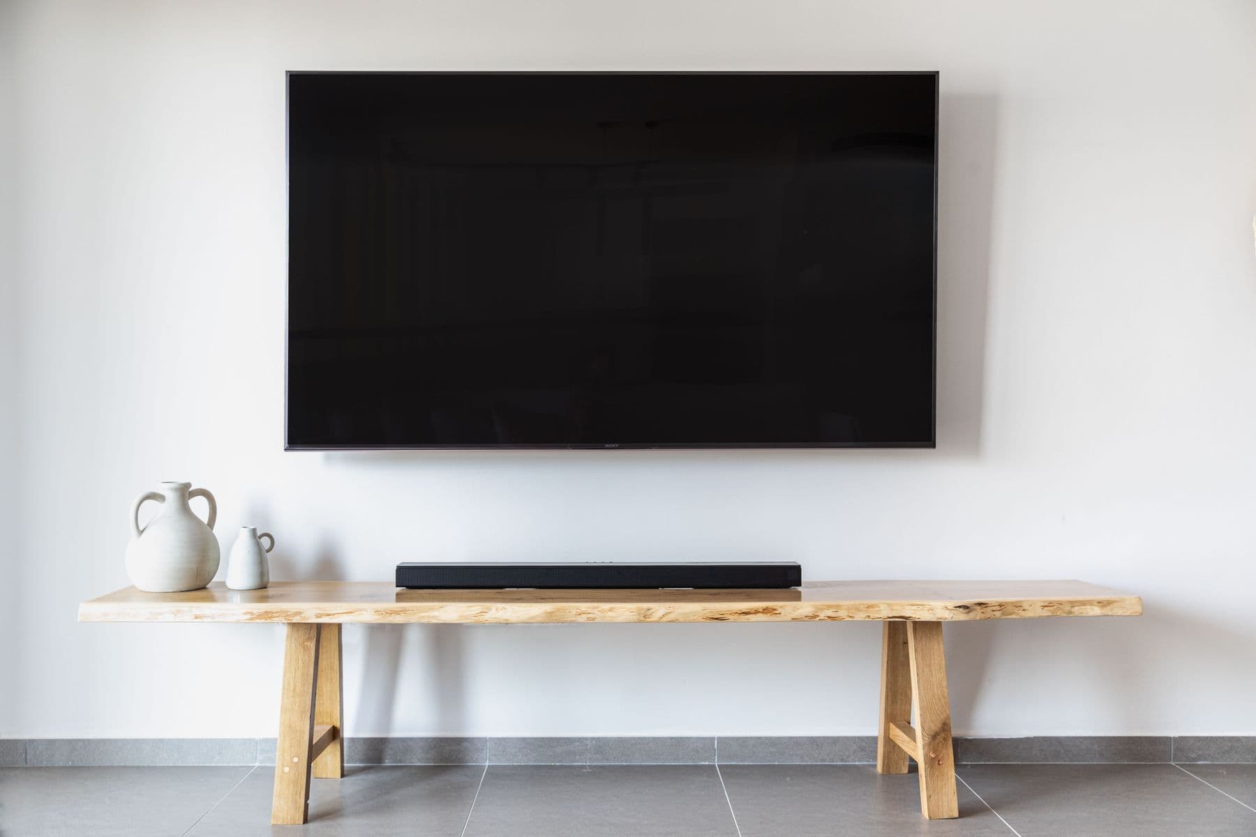 A slim TV mounted dead flat and level against a plain white wall, sitting flush like a framed picture
